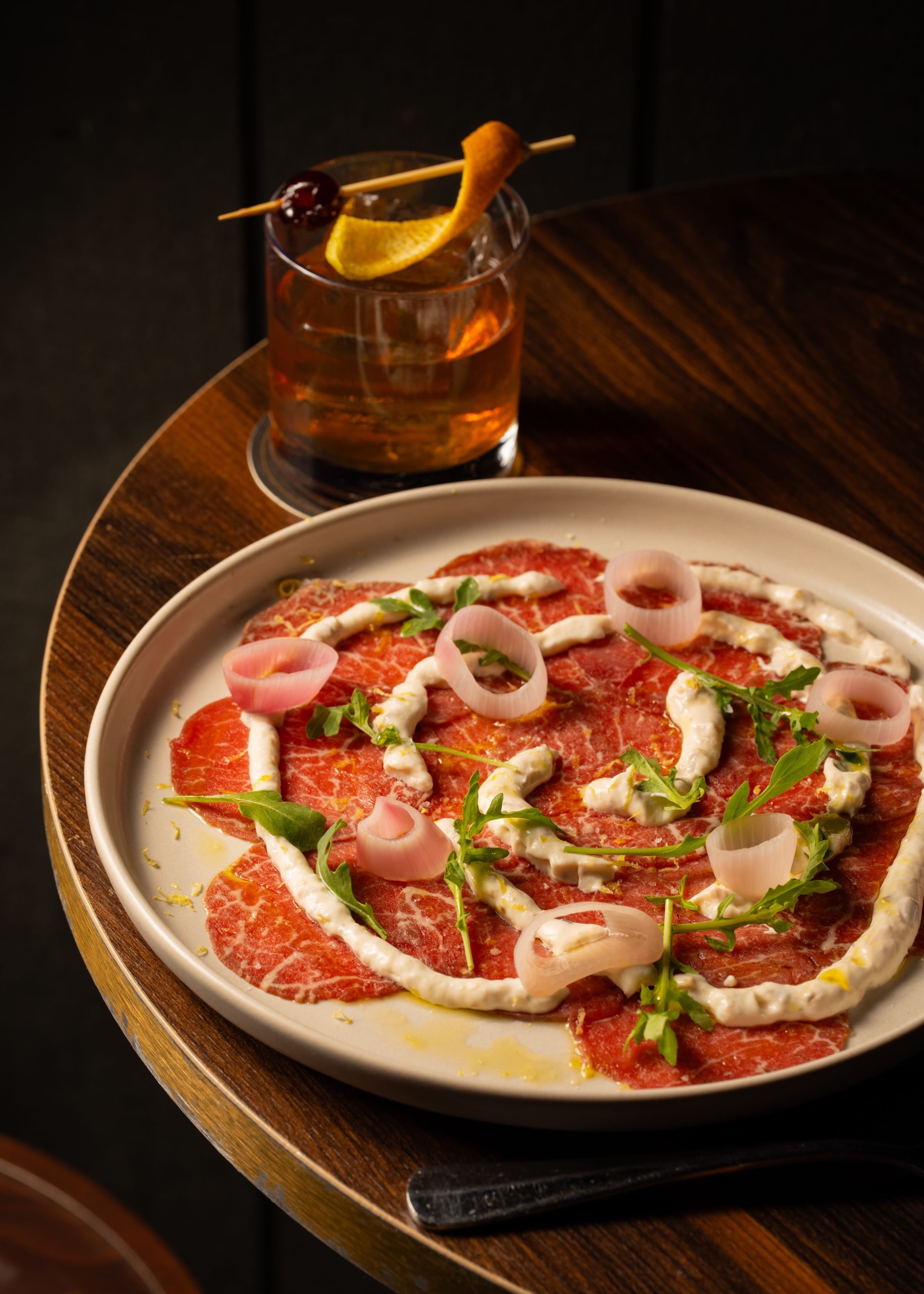 Beef carpaccio with rocket and pickled onion at Employees Only Sydney