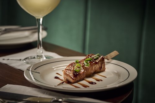 Glazed teriyaki salmon skewer with a cocktail at Employees Only Sydney