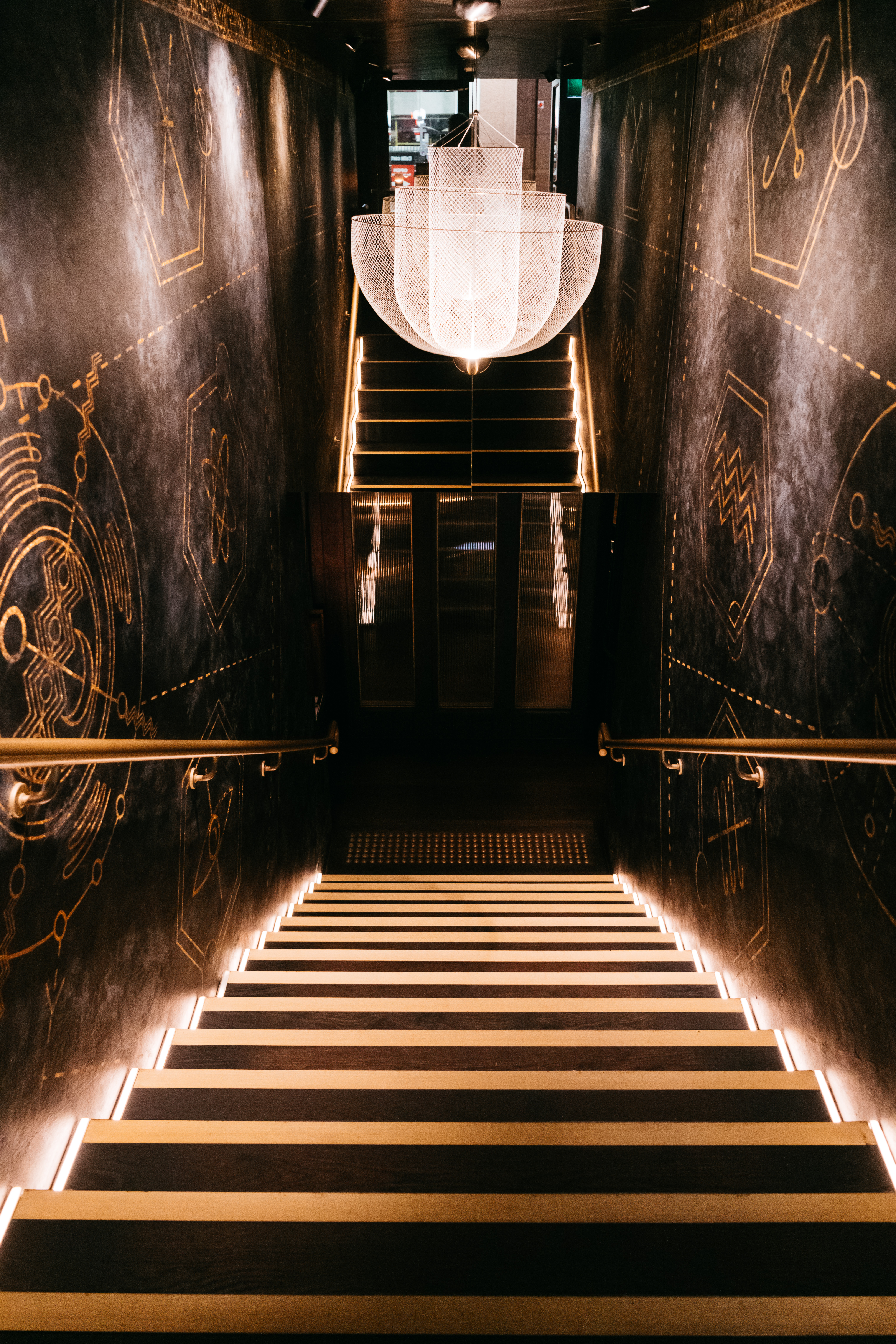Zodiac descent staircase with chandelier